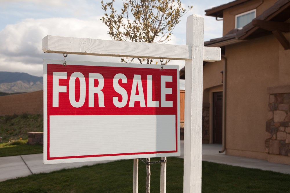 A photo of a for sale sign in front of a house illustrating someone Selling Your Home